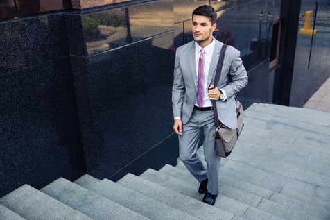 Confident businessman walking on stairs outdoors