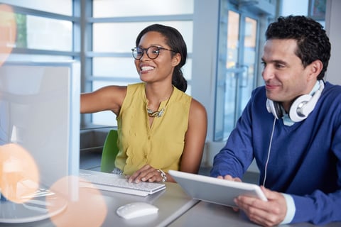 Two  colleages discussing ideas using a tablet and computer-2