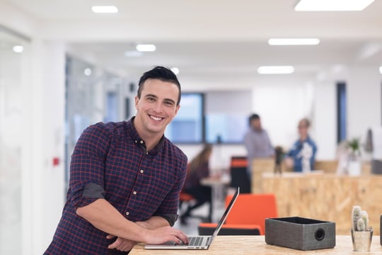 portrait of young businessman in casual clothes at modern startup business office space, working on laptop computer